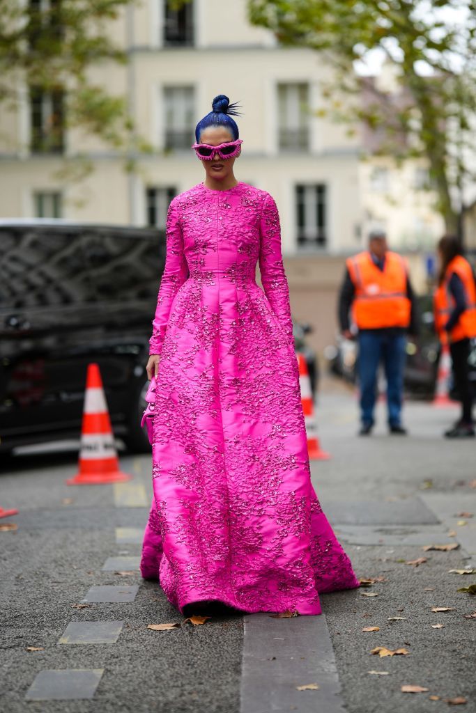 paris, france october 02 sita abellan wears neon pink nailed studded sunglasses, a neon pink embossed pattern and embroidered sequined flower print pattern long sleeves long dress, a neon pink shiny leather handbag from valentino, outside valentino, during paris fashion week womenswear springsummer 2023, on october 02, 2022 in paris, france photo by edward berthelotgetty images