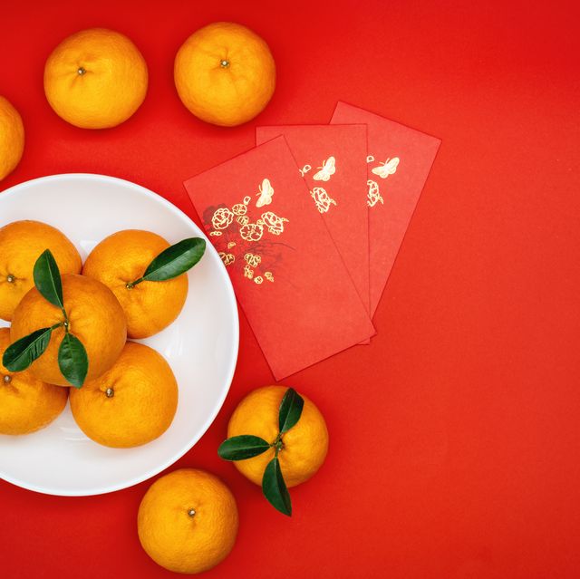 lunar new year decorations mandarin oranges and red envelopes on red background for chinese new year