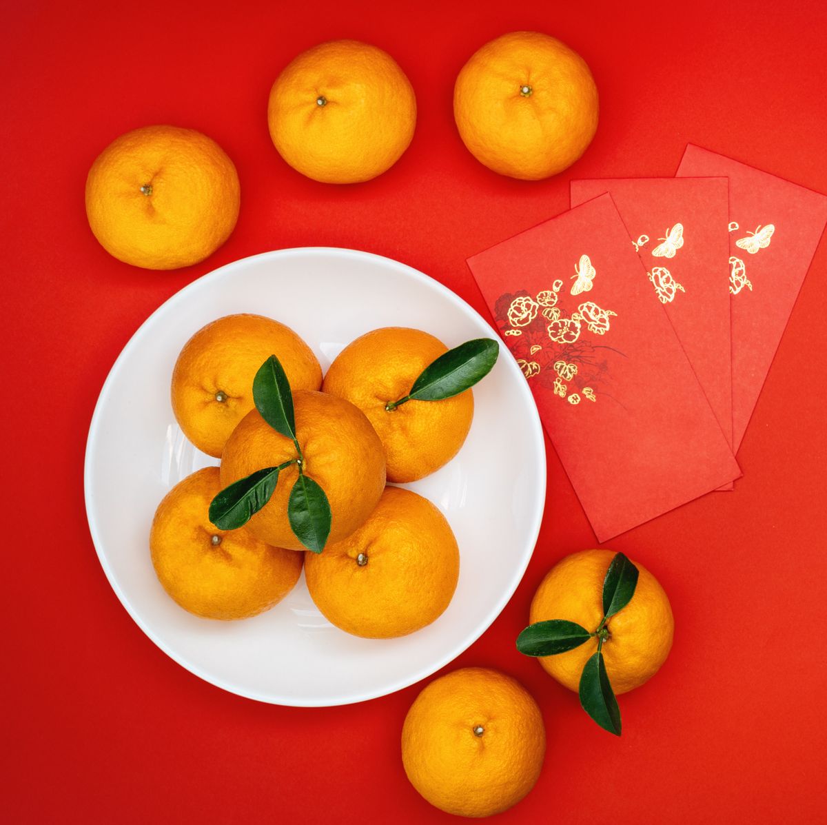 lunar new year decorations mandarin oranges and red envelopes on red background for chinese new year