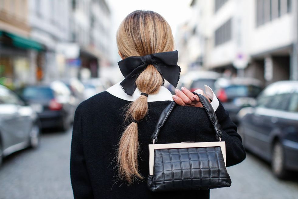 dusseldorf, germany february 06 a low bubble ponytail hairstyle, a black bow hair clip by chanel and a black and white bag by chanel as a detail of influencer gitta banko during a street style shooting on february 6, 2021 in dusseldorf, germany photo by streetstyleshootersgetty images