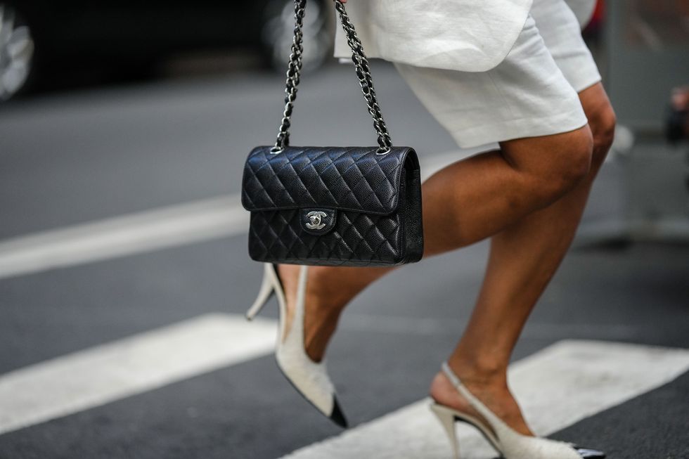 new york, new york september 13 a guest wears a white oversized linen blazer jacket, high waist white linen shorts, a black shiny leather timeless handbag from chanel, white tweed with black shiny varnished leather pointed pumps heels shoes from chanel , outside peter do, during new york fashion week, on september 13, 2022 in new york city photo by edward berthelotgetty images