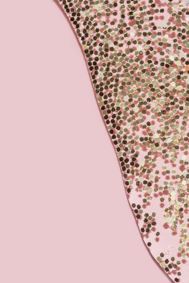 transparent liquid with gold glitter pouring over a pastel pink background festive backdrop for your project
