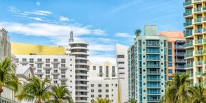 miami south beach ocean drive road street with famous retro art deco hotel colorful buildings cityscape with palm trees and blue sky on sunny day