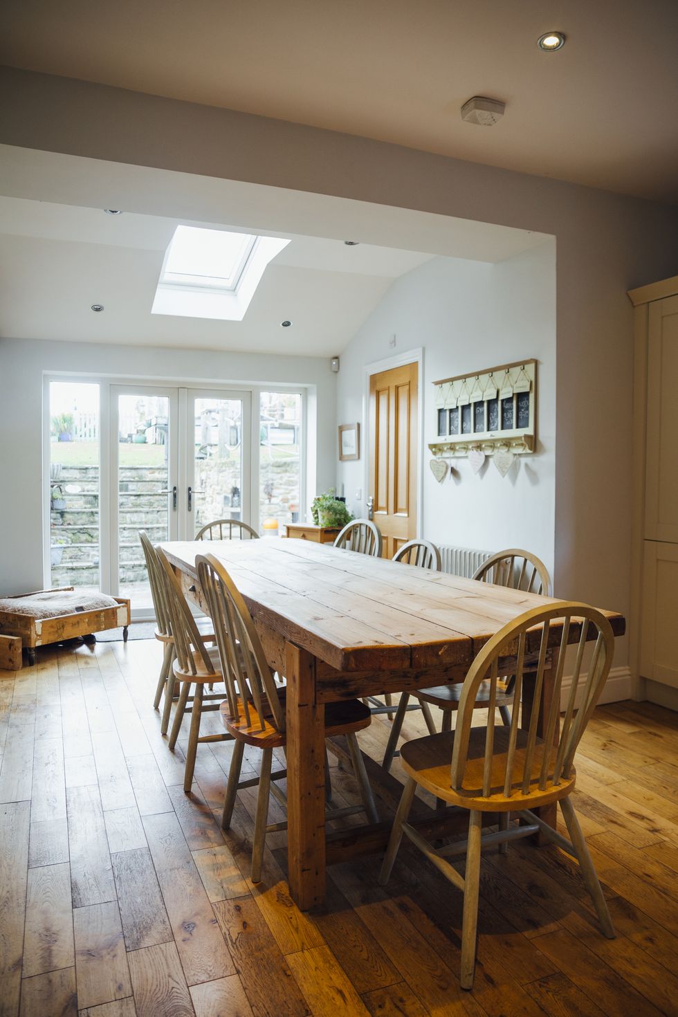 a wide angle view of a country style kitchen in a family home in northumberland in the north east of england with a long dining table for a large family