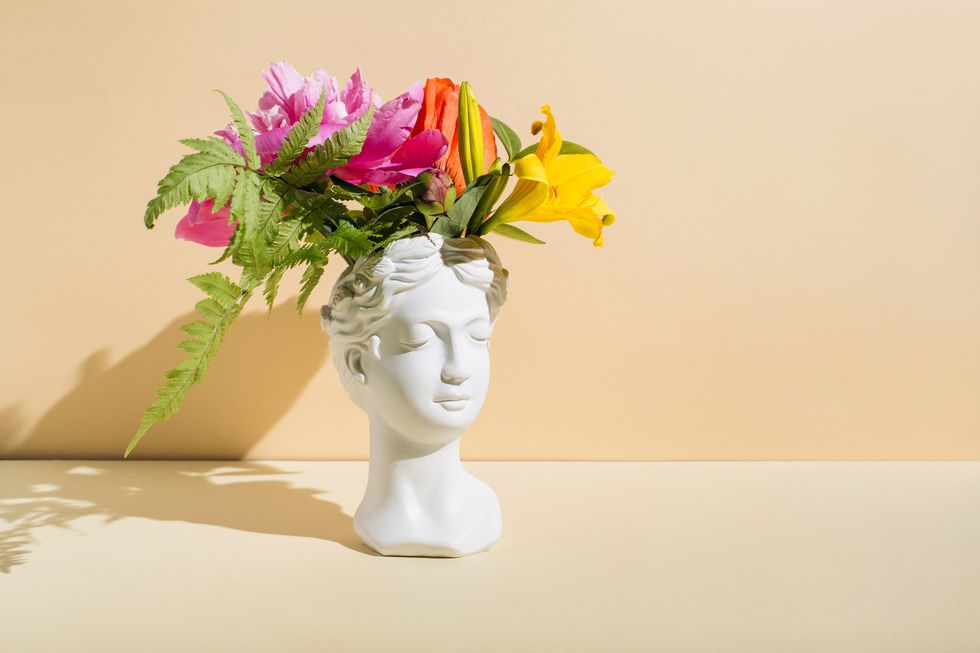 retro head sculpture with flowers on beige background creative positive thinking concept minimal mental health awareness month psychology, emotional wellness, progress, flowering, work on yourself idea