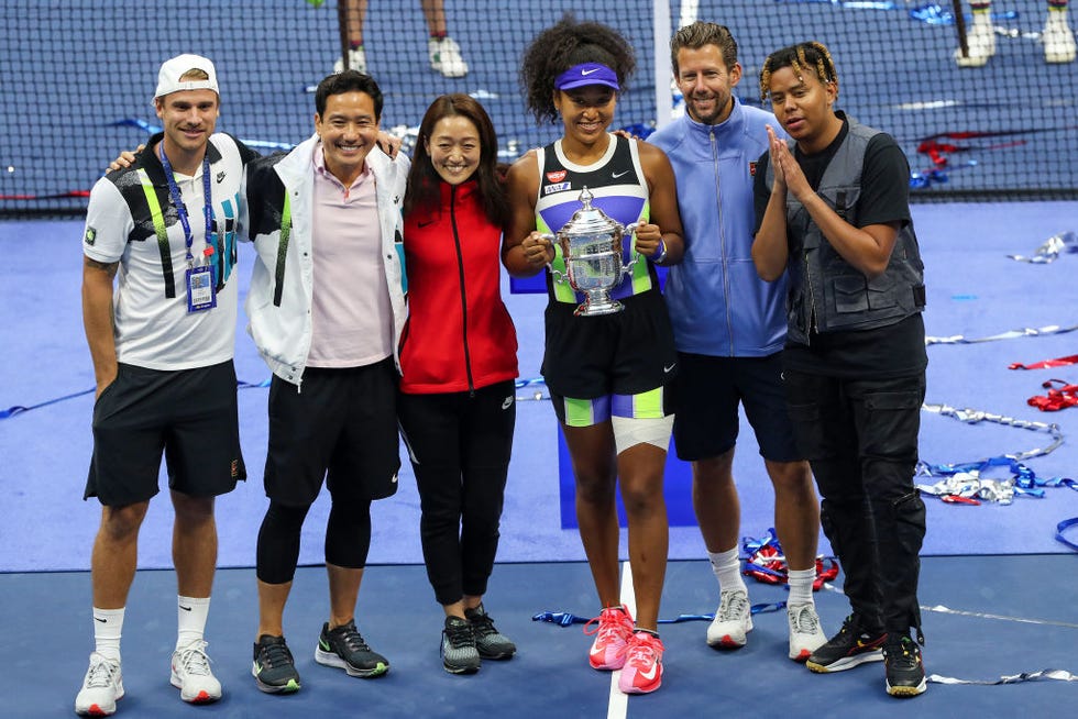 new york, new york september 12 naomi osaka 3rd r of japan holds the trophy and celebrates with her team and boyfriend, rapper ybn cordae r, after winning her womens singles final match against victoria azarenka of belarus on day thirteen of the 2020 us open at the usta billie jean king national tennis center on september 12, 2020 in the queens borough of new york city photo by matthew stockmangetty images