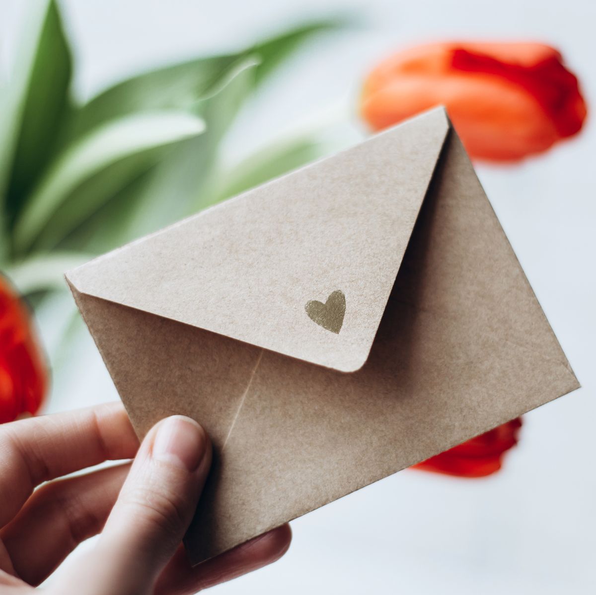 wedding card messages hand holding an open envelope with a heart on it