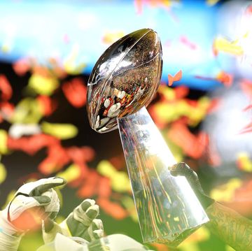 vince lombardi trophy held in front of a background of red and yellow confetti