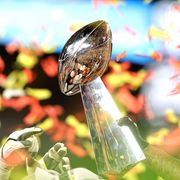 vince lombardi trophy held in front of a background of red and yellow confetti