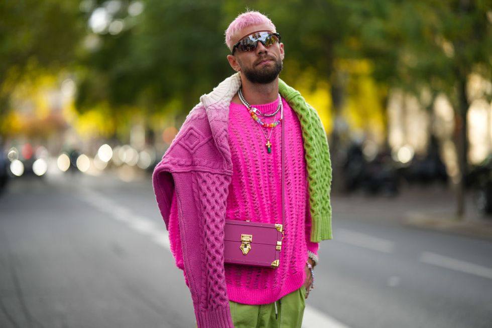 paris, france september 28 karb wears black sunglasses, silver and pearls pendant earrings, a neon pink wool oversized pullover, a half pink and half green braided wool pullover, a pink shiny leather crossbody bag, green cargo large pants, outside acne, during paris fashion week womenswear springsummer 2023, on september 28, 2022 in paris, france photo by edward berthelotgetty images