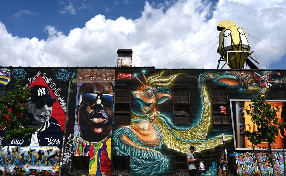 tourist pass by murals in the bushwick section of brooklyn, new york, on june 6, 2019 the art is part of the bushwick collective, nycs most prolific neighborhood for street art and graffiti photo by timothy a clary afp photo credit should read timothy a claryafp via getty images