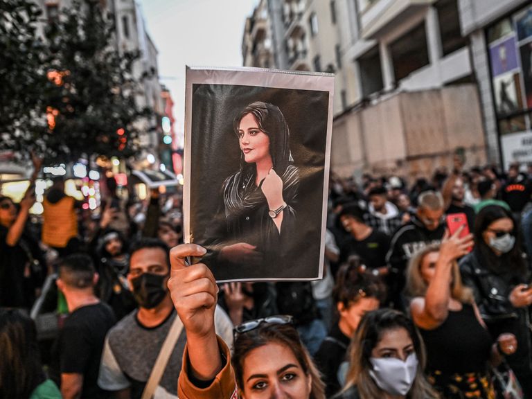topshot a protester holds a portrait of mahsa amini during a demonstration in support of amini, a young iranian woman who died after being arrested in tehran by the islamic republic's morality police, on istiklal avenue in istanbul on september 20, 2022 amini, 22, was on a visit with her family to the iranian capital when she was detained on september 13 by the police unit responsible for enforcing iran's strict dress code for women, including the wearing of the headscarf in public she was declared dead on september 16 by state television after having spent three days in a coma photo by ozan kose afp photo by ozan koseafp via getty images