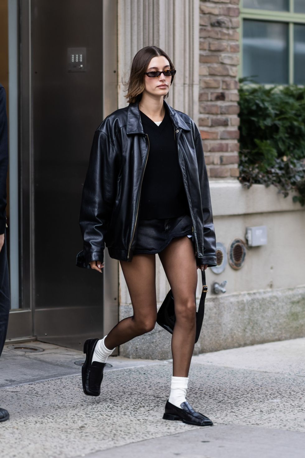 See Hailey Bieber Pair a Leather Coat with a Tiny Skirt and Tights in NYC