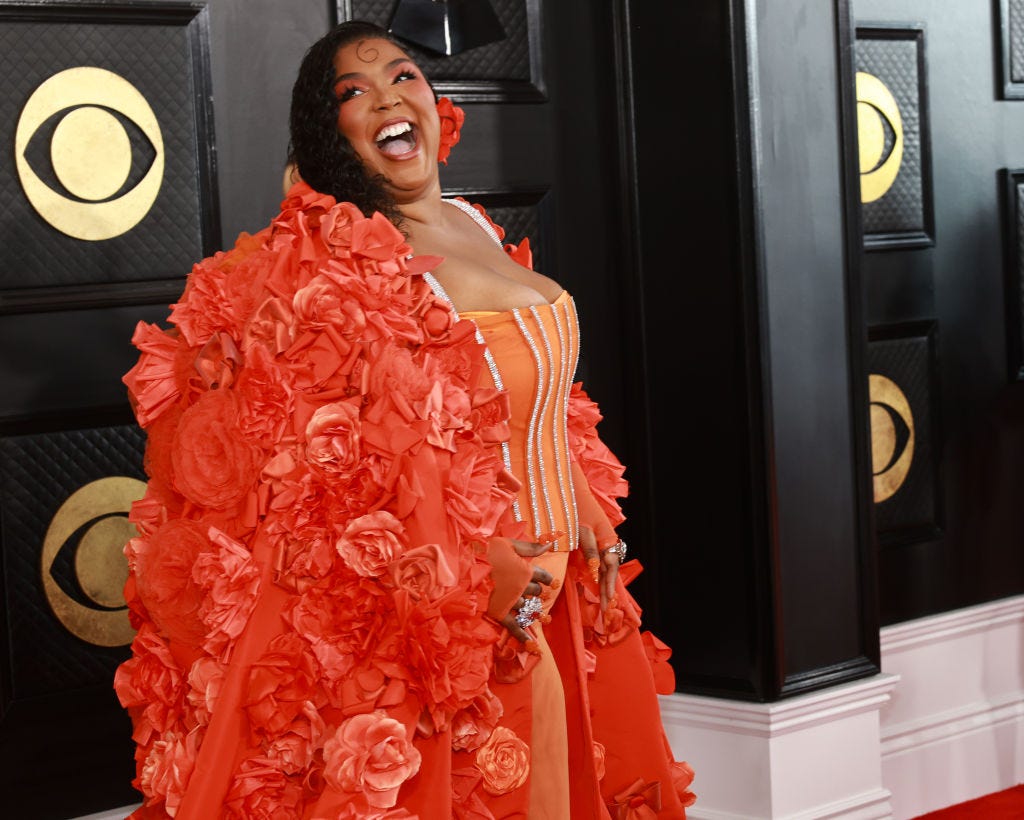 Lizzo looks peachy in corset, cape on Grammys 2023 red carpet