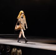 a model in a brown jacket and matching miniskirt walks the runway at the celine at the wiltern show in los angeles