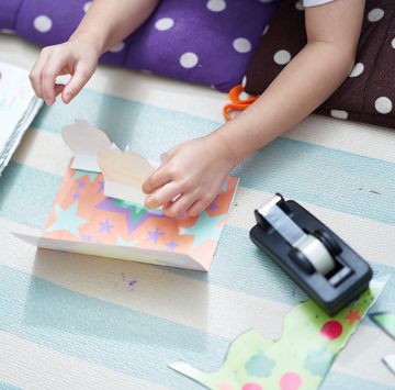 boy making a pop up card with coloured paper and sellotape