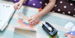 boy making a pop up card with coloured paper and sellotape