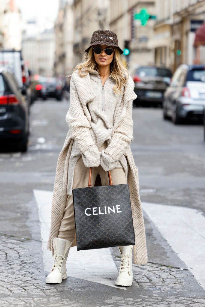 paris, france september 28 influencer gitta banko wearing a nude look with a beige knitted turtleneck pullover with zipper by marys by mary, a long beige knitted cashmere coat by simone bruns, beige cashmere pants by simone bruns, ivory colored boots by dior, a brown bucket hat with triomphe monogram pattern by celine, sunglasses by ray ban and a brown vertical cabas canvas bag with triomphe monogram pattern by celine, seen during the paris fashion week day two on september 28, 2021 in paris, france photo by streetstyleshootersgetty images