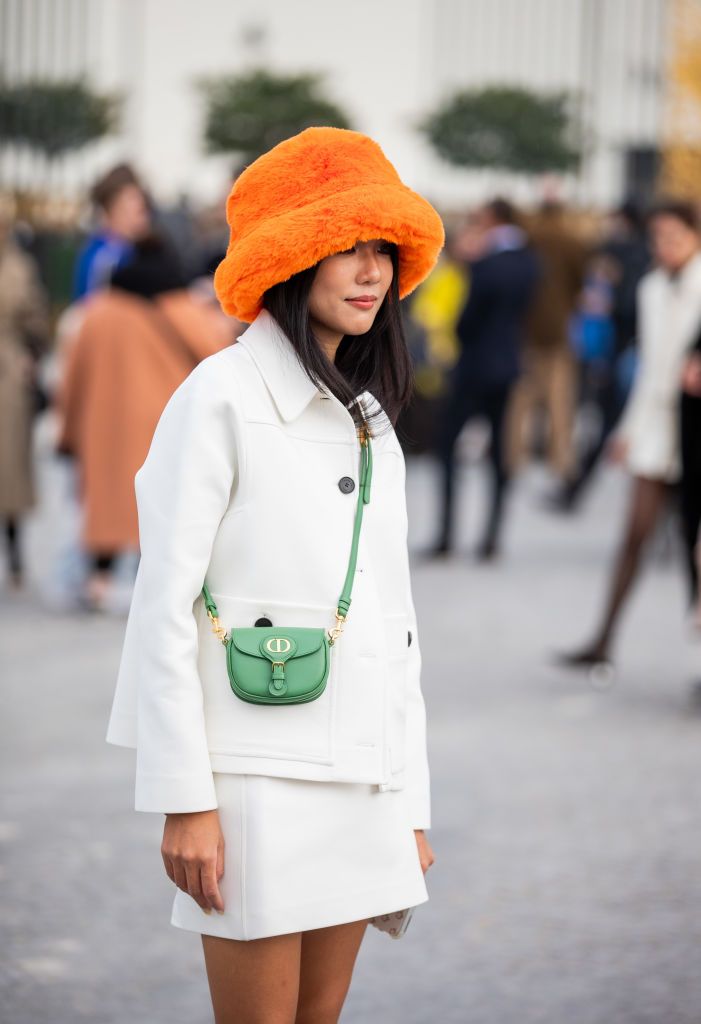 paris, france march 01 yoyo cao is seen wearing orange bucket hat, white blazer, skirt, green mini bag, ankle boots outside dior during paris fashion week womenswear fw 2022 2023 on march 01, 2022 in paris, france photo by christian vieriggetty images