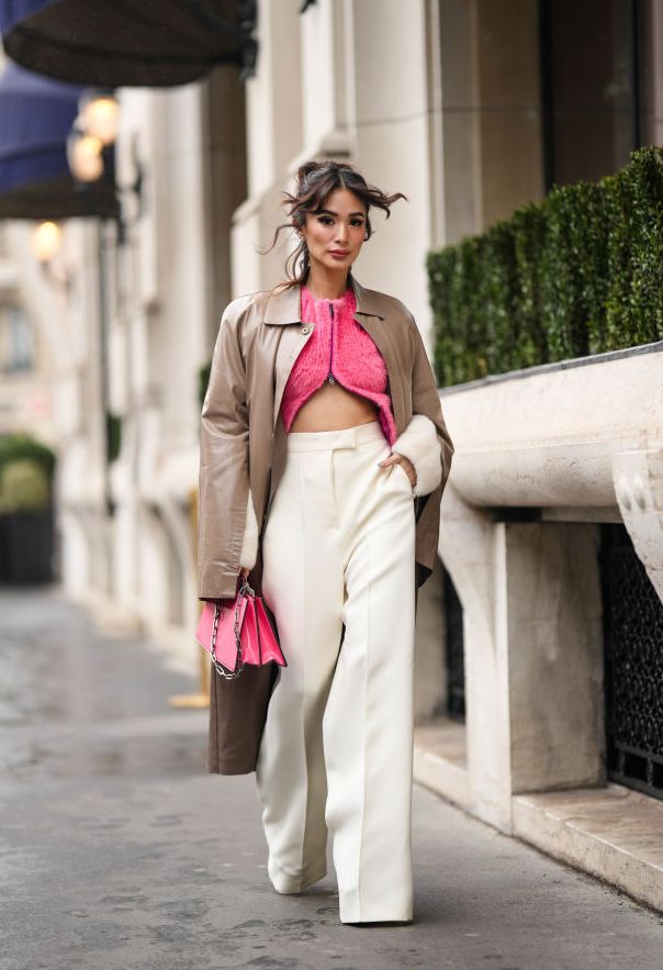 paris, france january 26 heart evangelista wears a green and silver f earrings from fendi, diamonds earrings, a pink fluffy zipper t shirt from fendi , high waist white latte wide legs pants from fendi a brown shiny leather long coat from fendi, a pink shiny varnished leather handbag from fendi, pumps heels shoes , before fendi, during paris fashion week haute couture spring summer on january 26, 2023 in paris, france photo by edward berthelotgetty images
