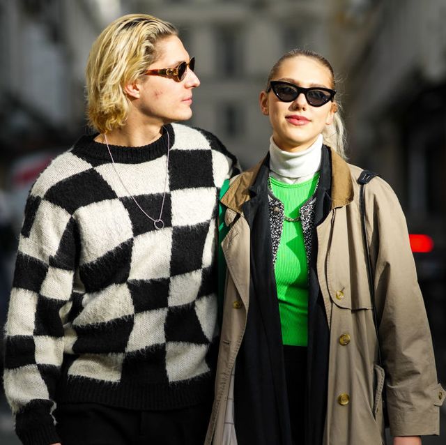 paris, france january 20 a guest l wears black sunglasses, a black and white checkered print pattern fluffy pullover, a silver long chain pendant necklace, a guest r wears black vintage sunglasses, a white ribbed turtleneck pullover, a neon green ribbed t shirt a beige long coat, a green and white checkered shiny leather shoulder bag, outside louis vuitton, during paris fashion week menswear fw 2022 2023, on january 20, 2022 in paris, france photo by edward berthelotgetty images