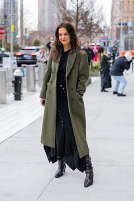 new york, new york february 12 katie holmes wears green coat, black dress, boots, bag outside ulla johnson during new york fashion week on february 12, 2023 in new york city photo by christian vieriggetty images