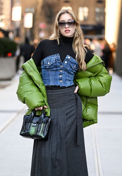 new york, new york february 11 ella blashka is seen wearing a green puff coat, jean top, black sweater and gray skirt with green snake skin leather bag outside the area show during new york fashion week fw 2023 on february 11, 2023 in new york city photo by daniel zuchnikgetty images