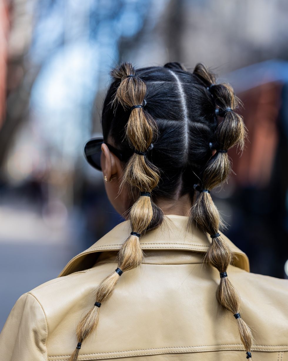 new york, new york february 13 pamela allier with pigtails wears denim dress, beige trench coat, brown boots outside coach during new york fashion week on february 13, 2023 in new york city photo by christian vieriggetty images