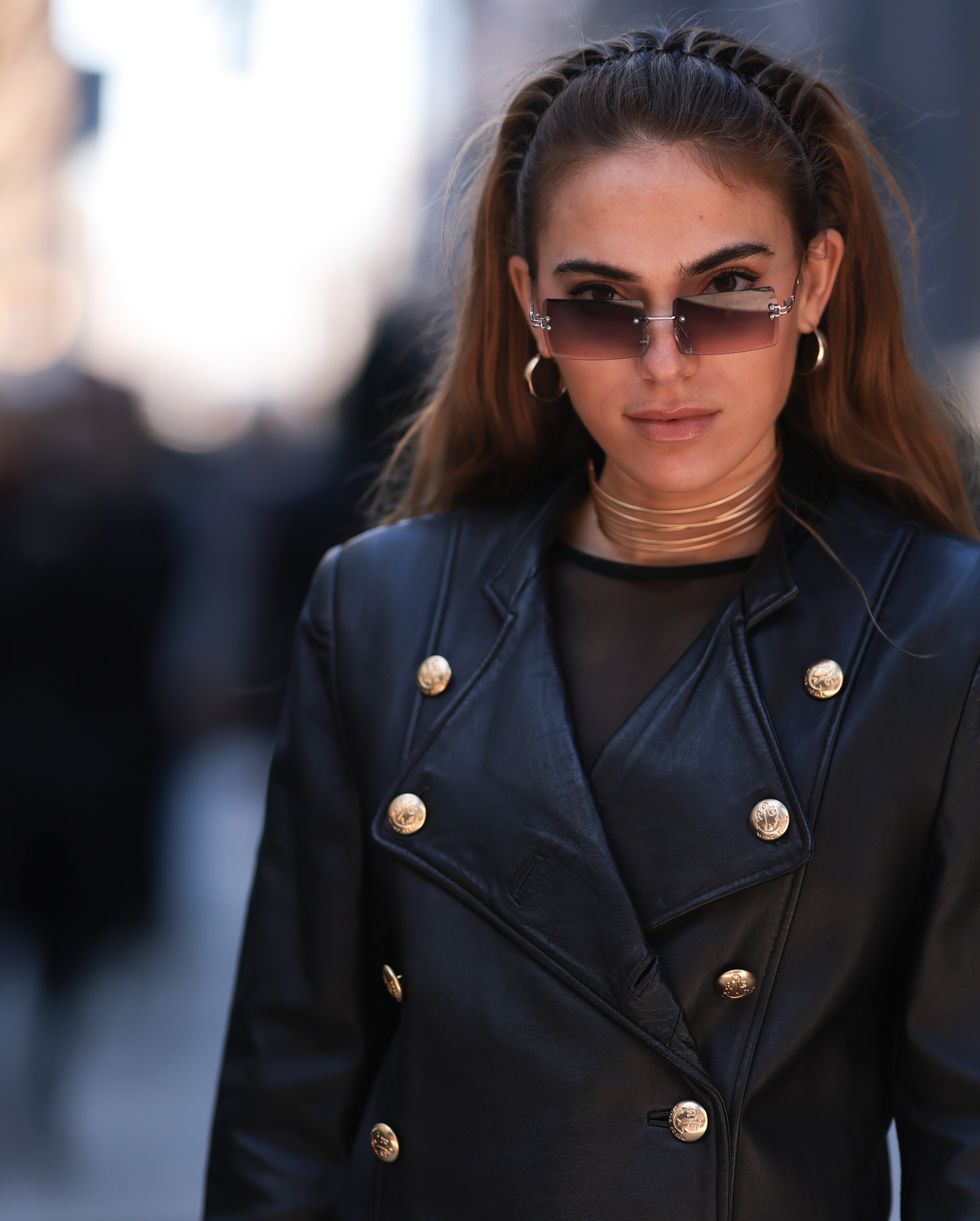 new york, new york february 11 a guest wears a double breasted leather jacket, double breasted black pants, mesh shirt, brown sunglasses, gold jewelry, outside before proenza schouler show during new york fashion week on february 11, 2023 in new york city photo by jeremy moellergetty images