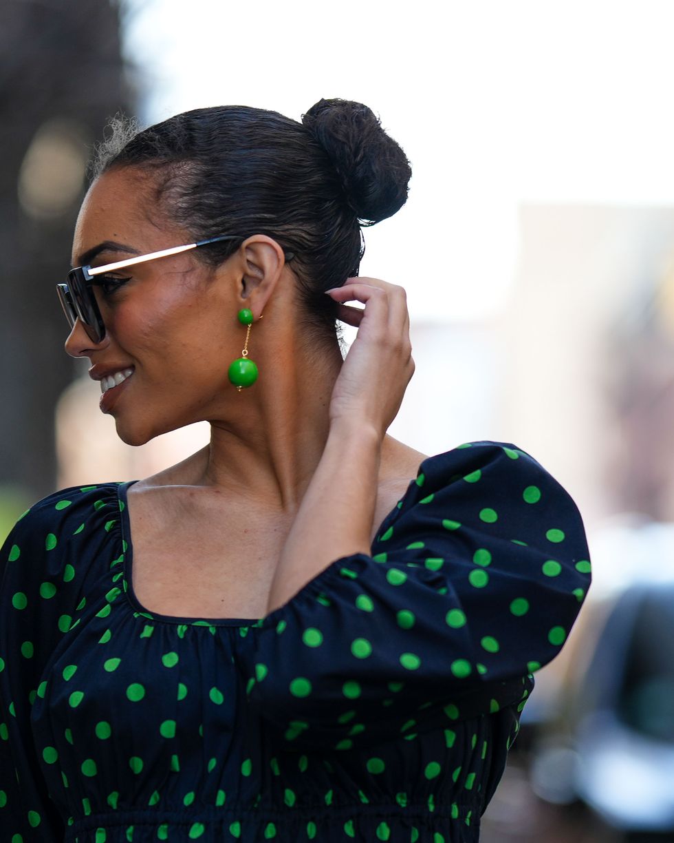 new york, new york february 10 a guest wears green pendant earrings, a black with green polka dots print pattern squared neck puffy long sleeves midi dress, outside kate spade, during new york fashion week, on february 10, 2023 in new york city photo by edward berthelotgetty images