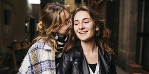 portrait of young lesbian couple on a narrow city street