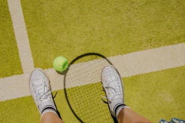 tennis ball and tennis racket shadow on a tennis court floor