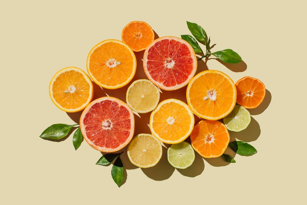 pattern of slices citrus fruit of lemons, oranges, grapefruit, lime on beige background healthy food, diet and detox concept flat lay, top view