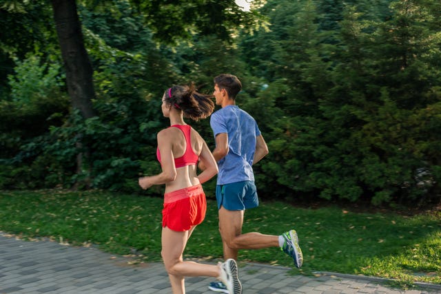 portrait of cheerful caucasian couple running outdoors sport family