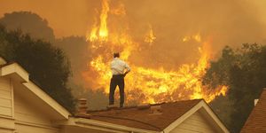 camarillo, ca   may 3  a man on a rooftop looks at approaching flames as the springs fire continues to grow on may 3, 2013 near camarillo, california the wildfire has spread to more than 18,000 acres on day two and is 20 percent contained  photo by david mcnewgetty images