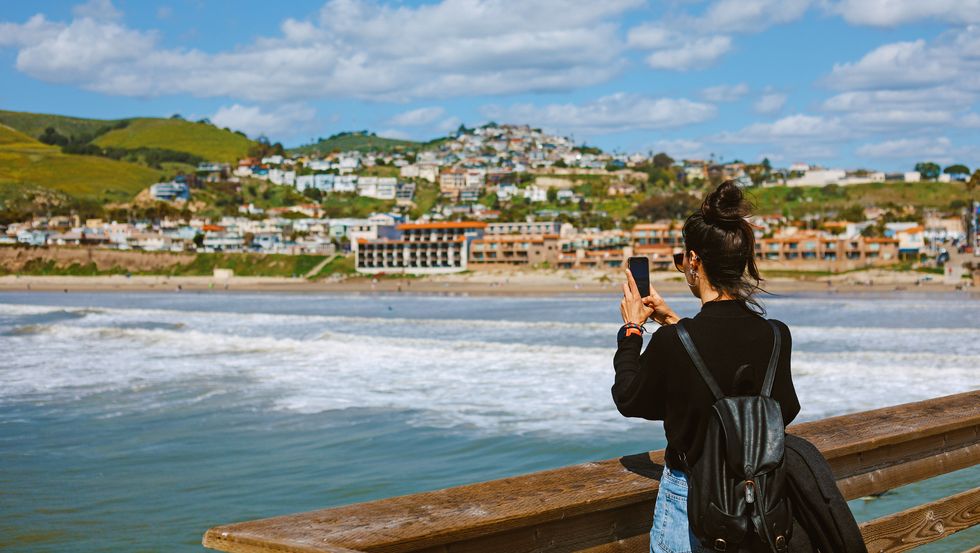a person taking a picture of a body of water and buildings