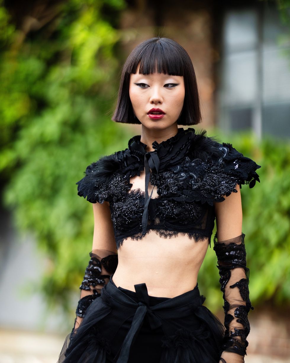milan, italy september 20 lin lin is seen wearing a black lace collar embroidered with black beans with a matching bra and gloves, black culotte, knee high black tight and a black tulle skirt outside antonio marras show during the milan fashion week womenswear springsummer 2024 on september 20, 2023 in milan, italy photo by valentina frugiuelegetty images