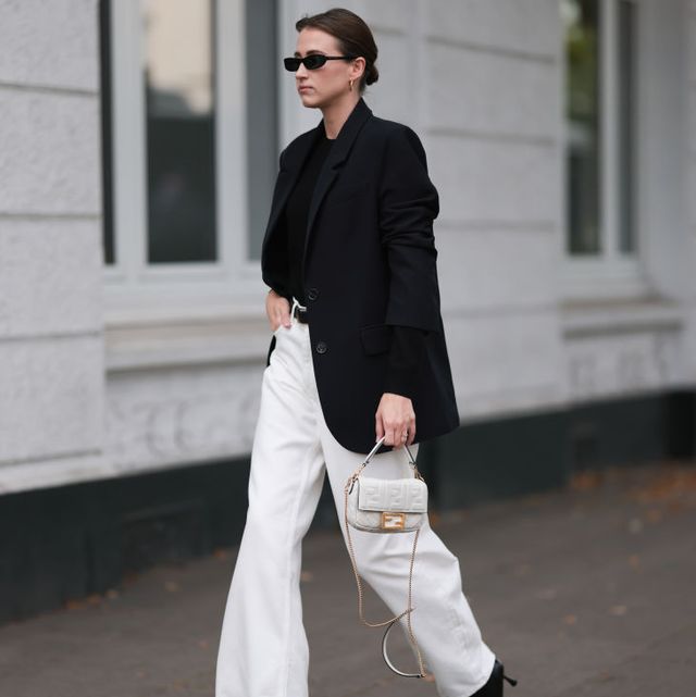 hamburg, germany september 20 marie danker is seen wearing black narrow sunglasses from carolina lemke, golden hoop earrings from missoma, a black long blazer with shoulder pads from leger, underneath a black cashmere pullover, wide white jeans pants from cos, a black leather belt with golden buckle from cos, the baguette bag from fendi in white leather and black leather boots with squared toecaps from zara on september 20, 2023 in hamburg, germany photo by jeremy moellergetty images