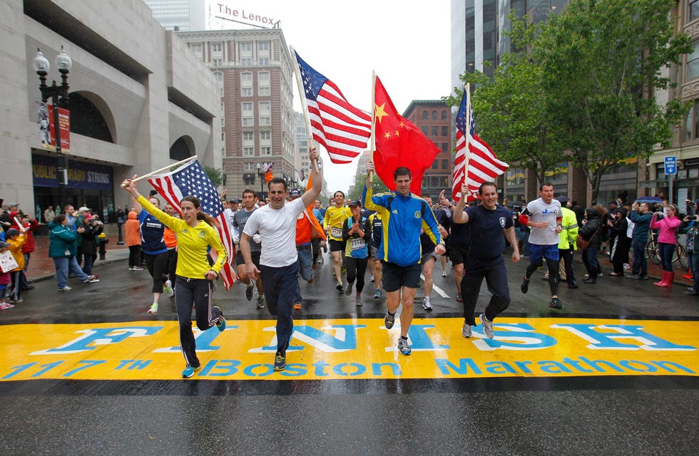 boston may 25 l r amanda watters, mike ross, kyle shade and mit shirt andrew truco carry flags as they cross the boston marathon finish line on boylston street during the boston strong one run in boston on may 25, 2013 the event was organized to allow runners who were stopped mid race after two explosions went off near the finish line on april 15 to complete final mile of the route photo by jessica rinaldi for the boston globe via getty images