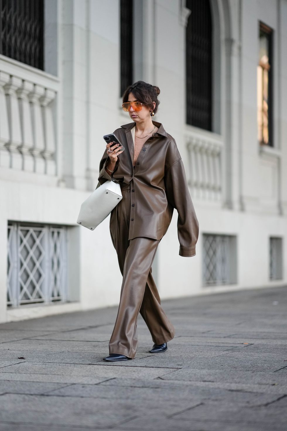A guest wears a camel bag, outside Fendi, during the Milan Fashion