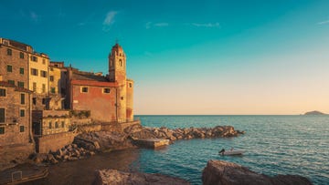 tellaro village at sunset the church and a small boat in the sea golfo dei poeti or gulf of poets liguria region, italy, europe