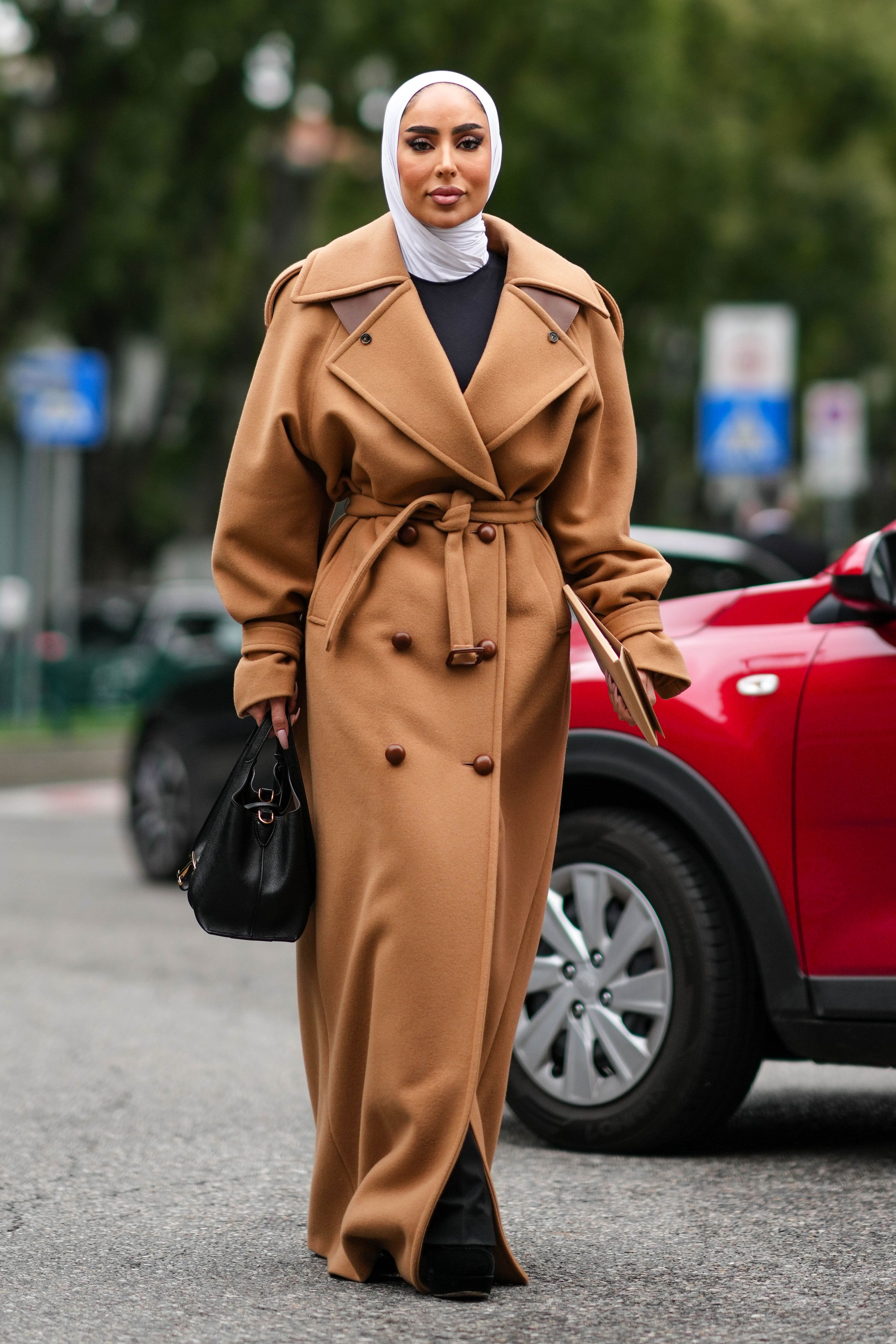 A passerby wears a white knitted long jacket, an orange leather News  Photo - Getty Images