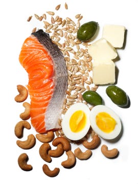 keto friendly foods on a white background: salmon, cashews, hard boiled eggs, olives, cheese, and seeds