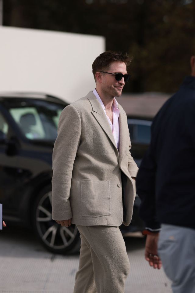 paris, france september 26 robert pattinson is seen wearing an christian dior outfit consisting of black sunglasses, a beige wool two piece suit with wide pants and a buttoned jacket, and a pink shirt before the christian dior womenswear springsummer 2024 show as part of paris fashion week on september 26, 2023 in paris, france photo by jeremy moellergetty images