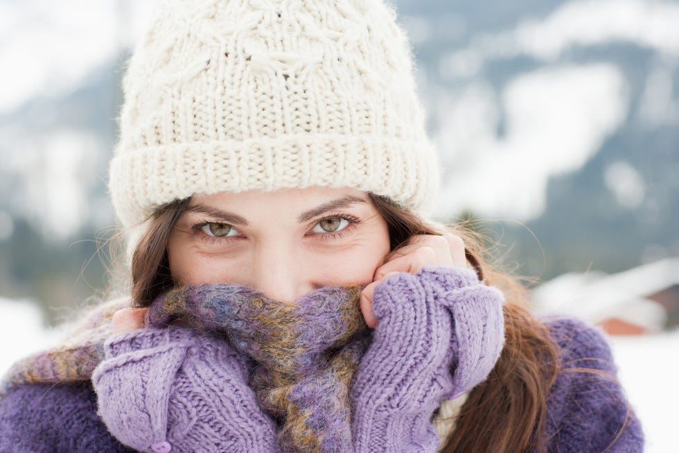 woman bundled up in scarf and woolly hat outdoors on a cold day