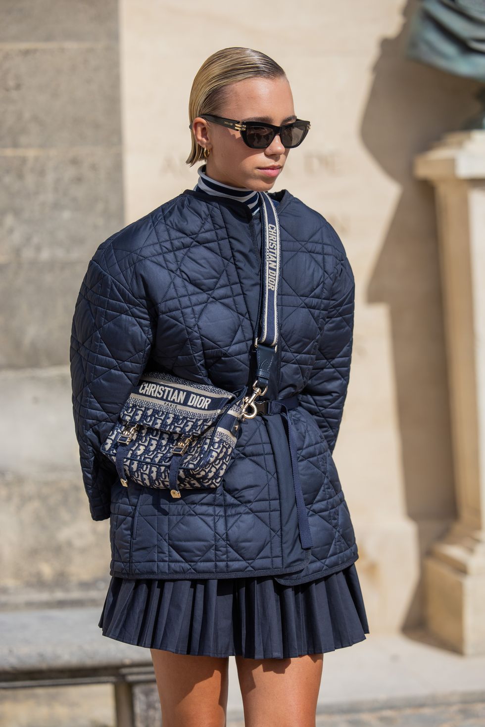 paris, france september 26 lena mantler wears navy puffer jacket, bag, pleated skirt, sunglasses outside dior during the womenswear springsummer 2024 as part of paris fashion week on september 26, 2023 in paris, france photo by christian vieriggetty images