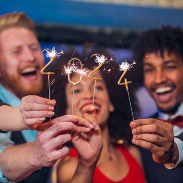 young happy people looking at sparklers in their hands
