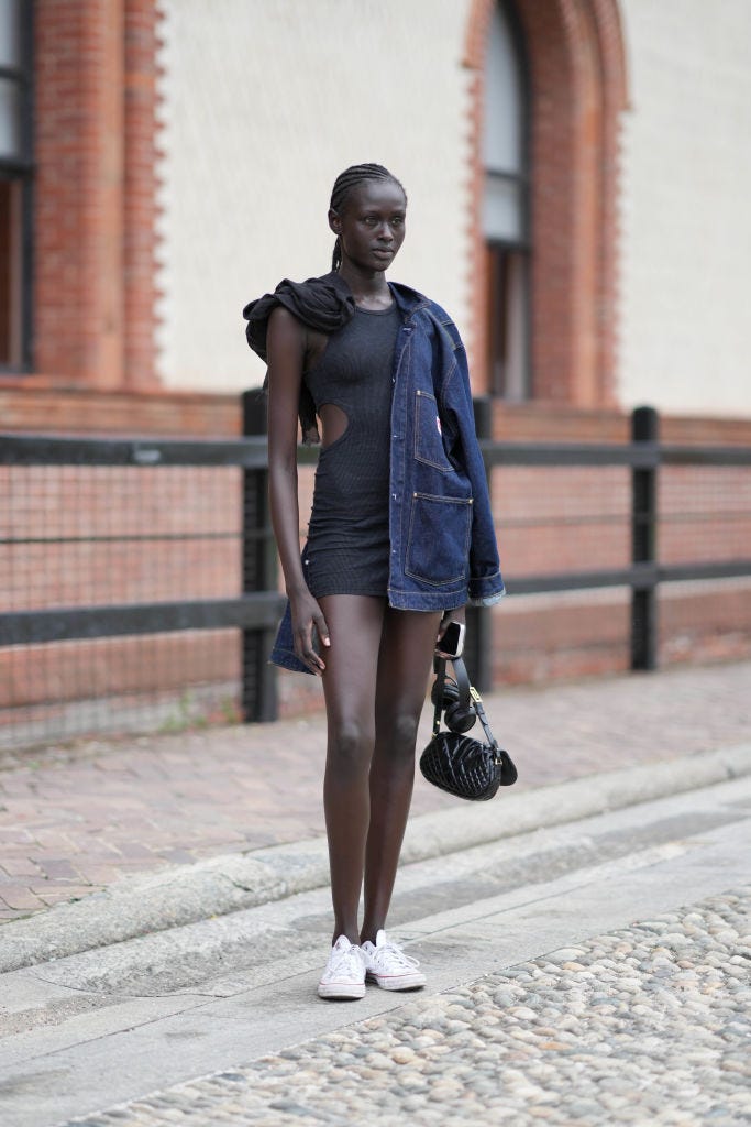 a woman wearing a mini dress and trainers
