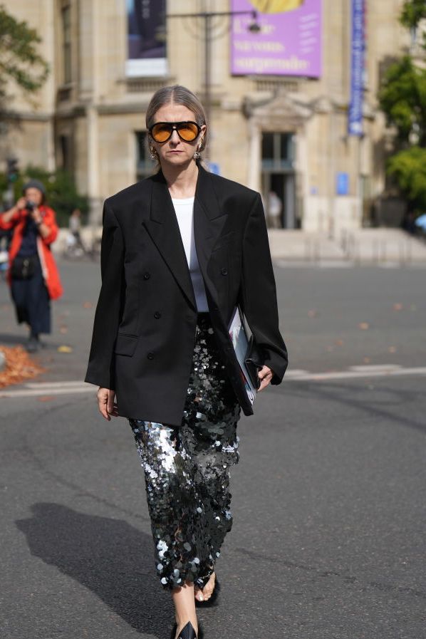 paris, france october 03 a guest wears orange sunglasses, a white t shirt, a black oversized blazer jacket, a midi silver shiny sequined skirt, sandals, outside miu miu, during the womenswear springsummer 2024 as part of paris fashion week on october 03, 2023 in paris, france photo by edward berthelotgetty images