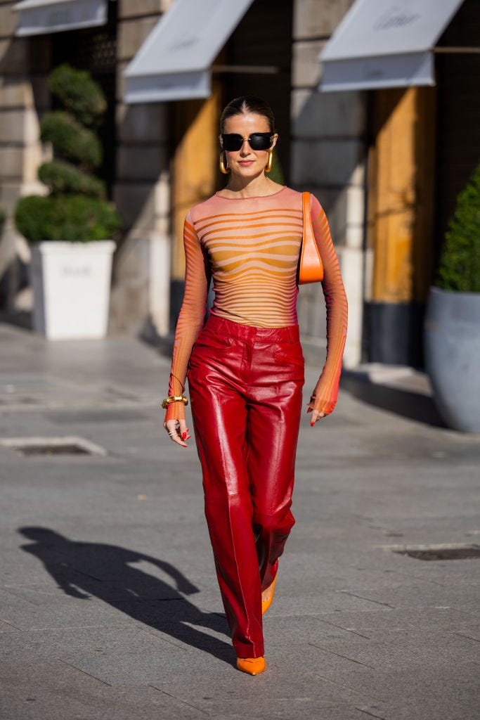 paris, france october 03 nina sandbech wears red leather pants, orange bag, transparent striped orange top, earrings, miu miu sunglasses, orange pointed prada heels outside during the womenswear springsummer 2024 as part of paris fashion week on october 03, 2023 in paris, france photo by christian vieriggetty images